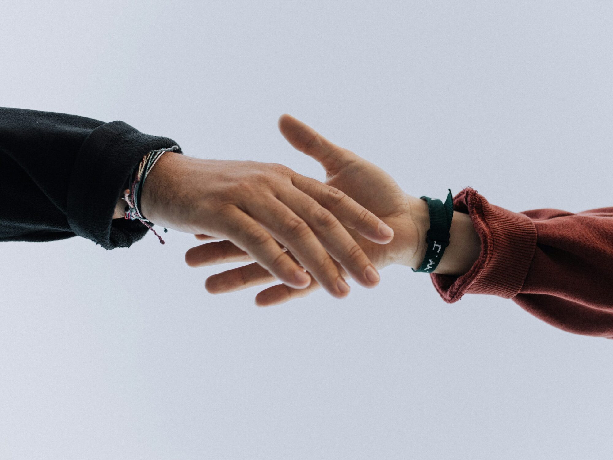 Zwei Personen reichen sich die Hände, Foto: Austin Kehmeier, unsplash